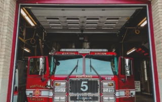 A Portland Fire Department Truck seen through the large open doorway of a fire station.