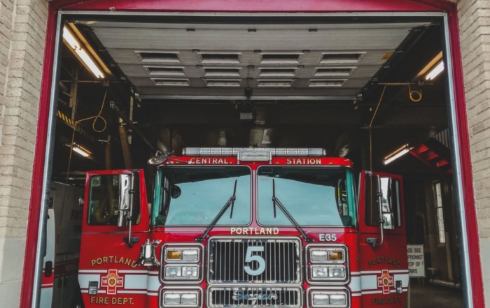 A Portland Fire Department Truck seen through the large open doorway of a fire station.